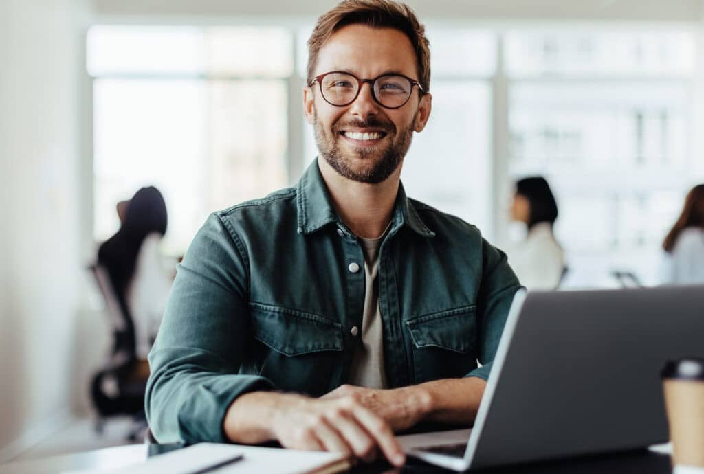 Zufriedener Mitarbeiter nutzt benutzerfreundliche digitale Personalverwaltung am Laptop